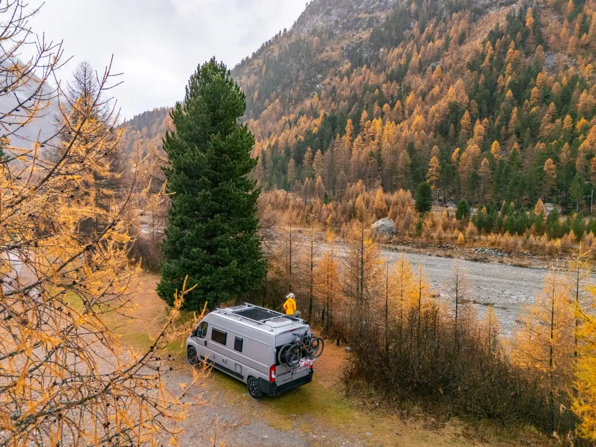 A campervan parked by a river