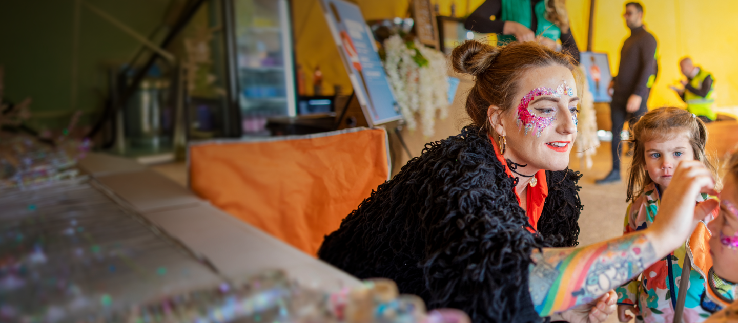 Face painter painting a design on a client
