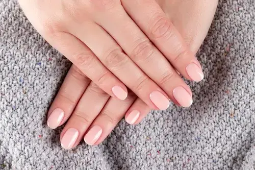 woman's hands with nude nail design