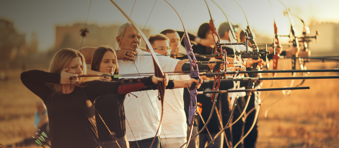 Line of people doing archery, with their bows ready