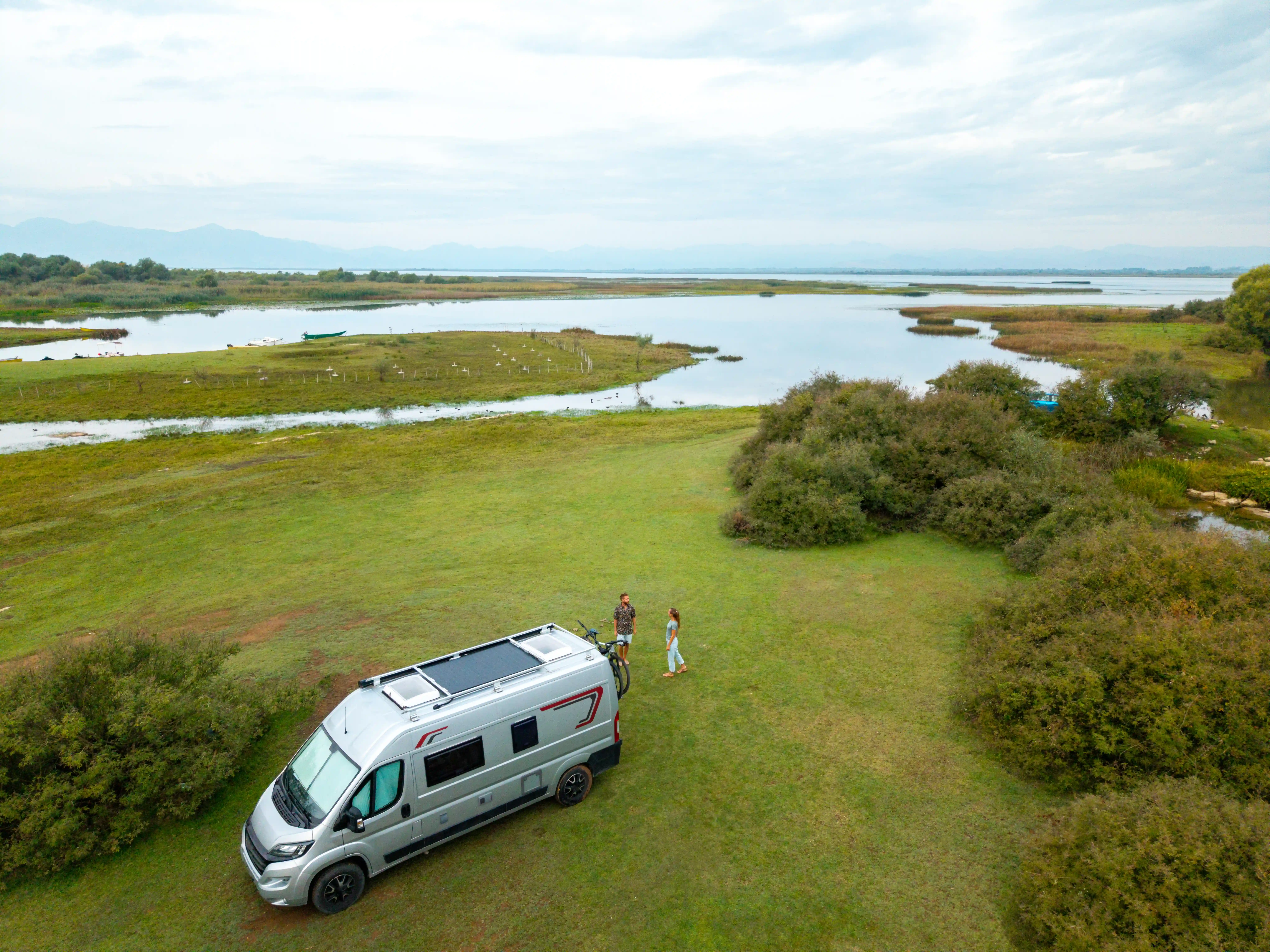 Campervan in a field next to a lake