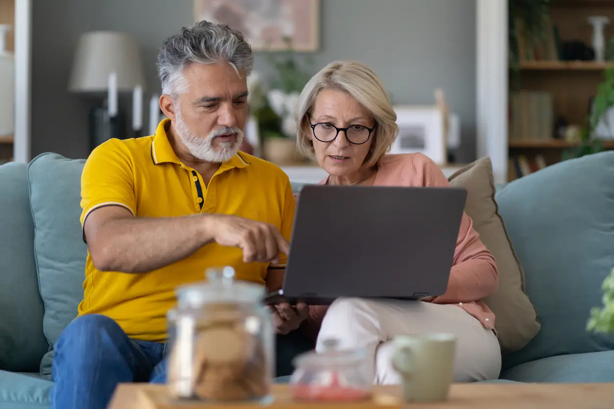 Couple looking at their laptop, concerned