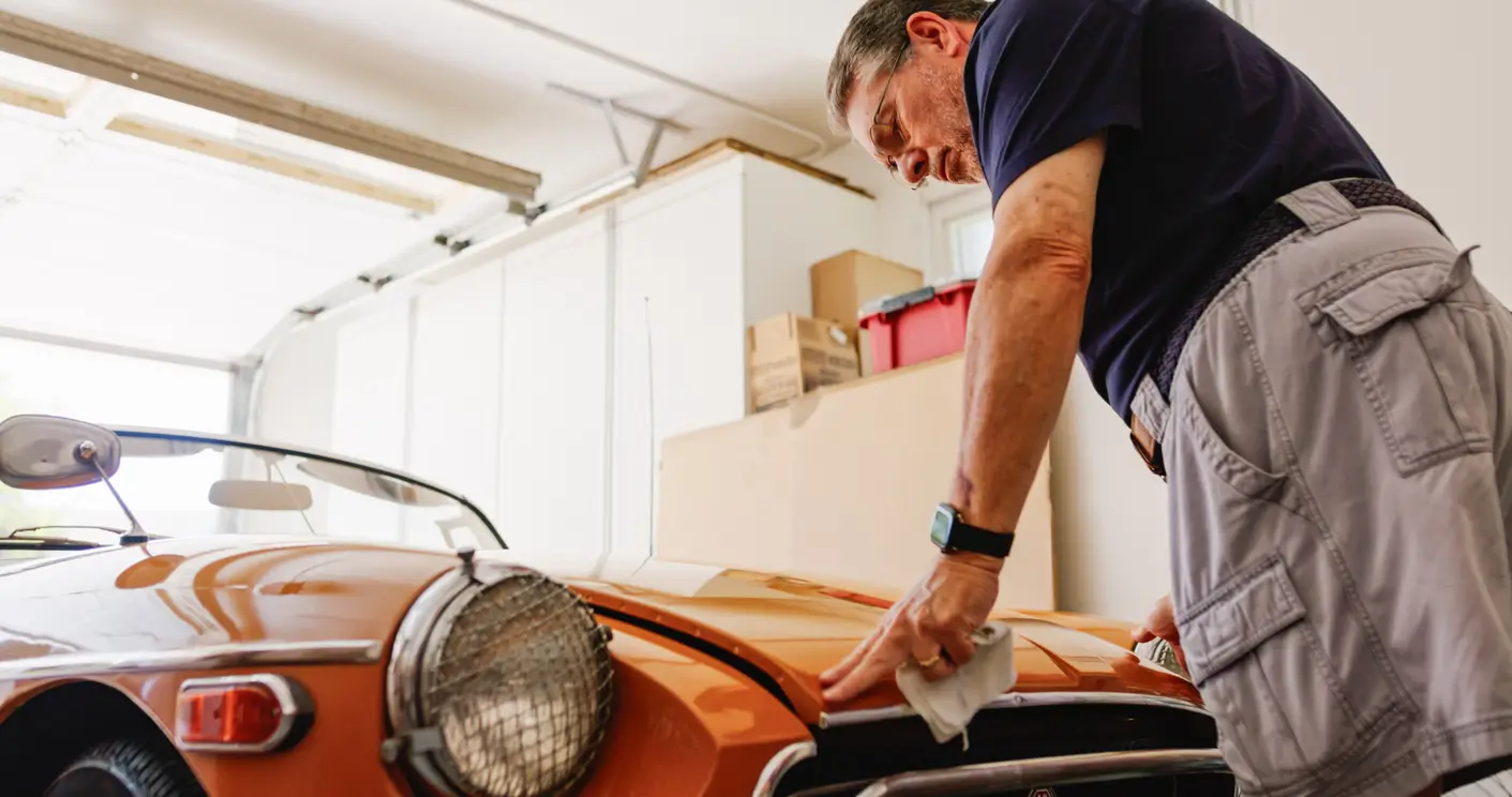 man looking at his classic car in his garage