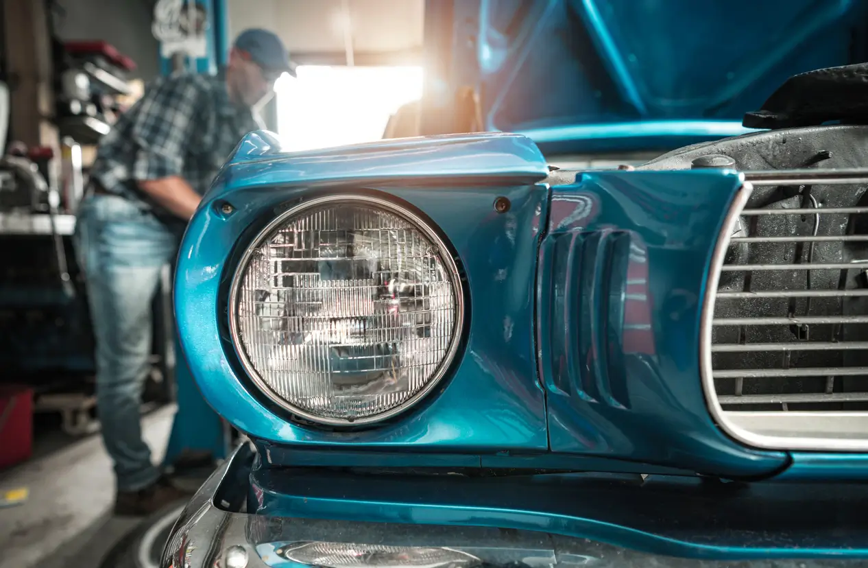 a mechanic working on restoring a classic car