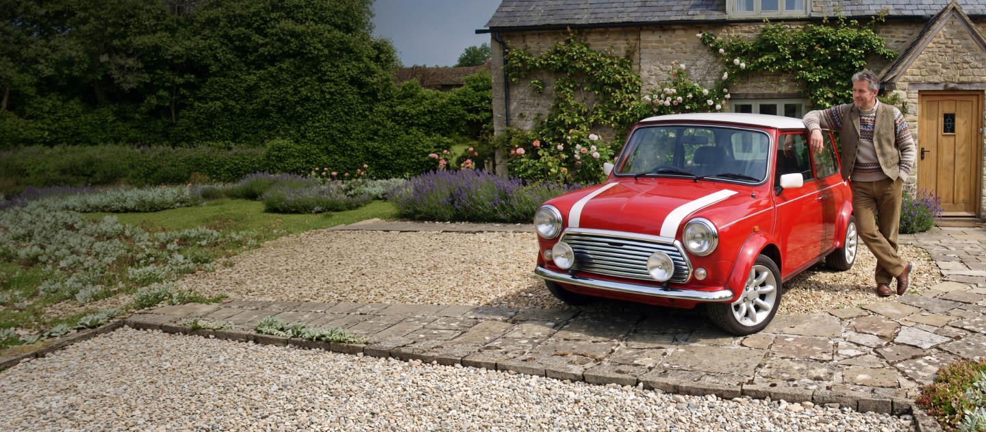 Man stood with his classic Mini in front of his house